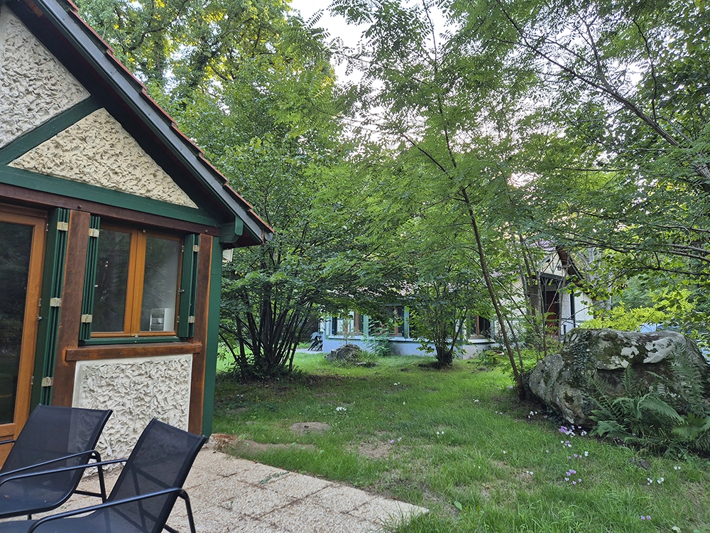Terrace of the apartment on the left and we can see the house through the hazel tree.