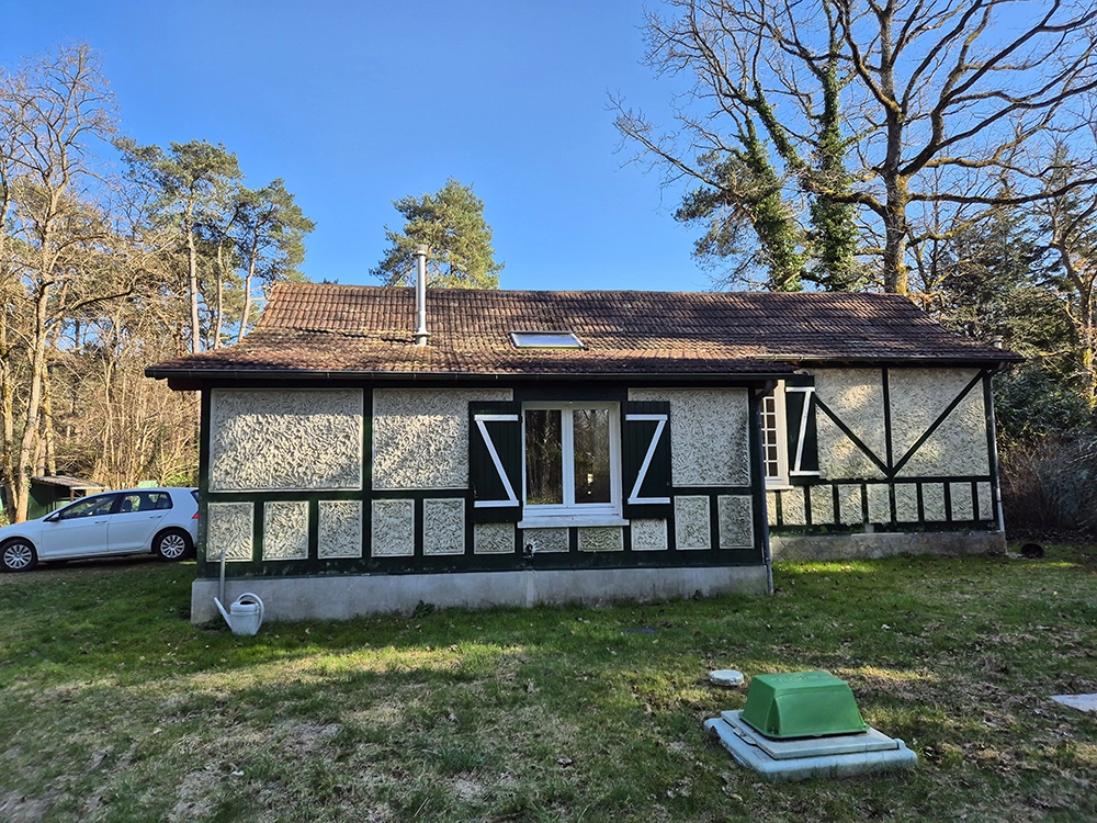 Outdoor view of the other side of the house with a white golf parked in front of it. Summer light.